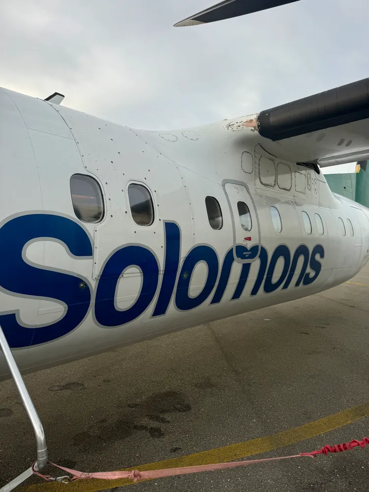 An aircraft fuselage lettered Solomons, seen from the apron