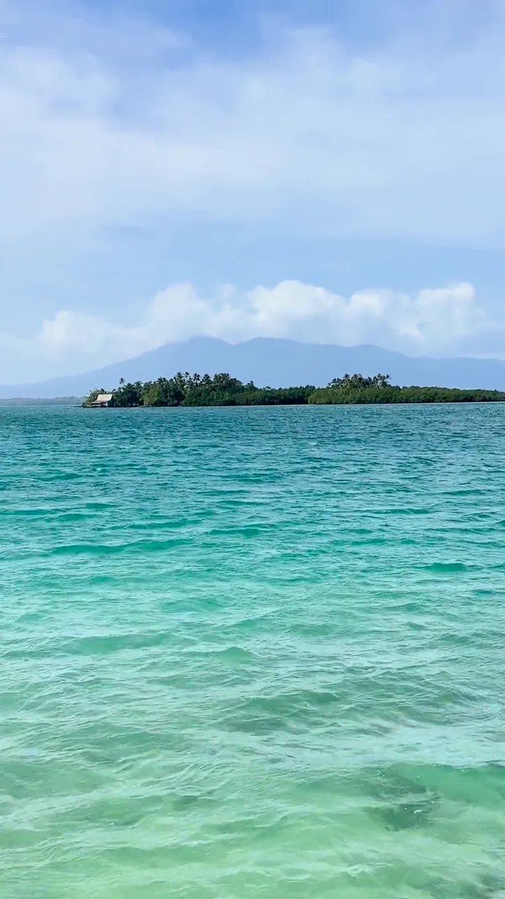 A turquoise lagoon and forested islets, seen from a boat