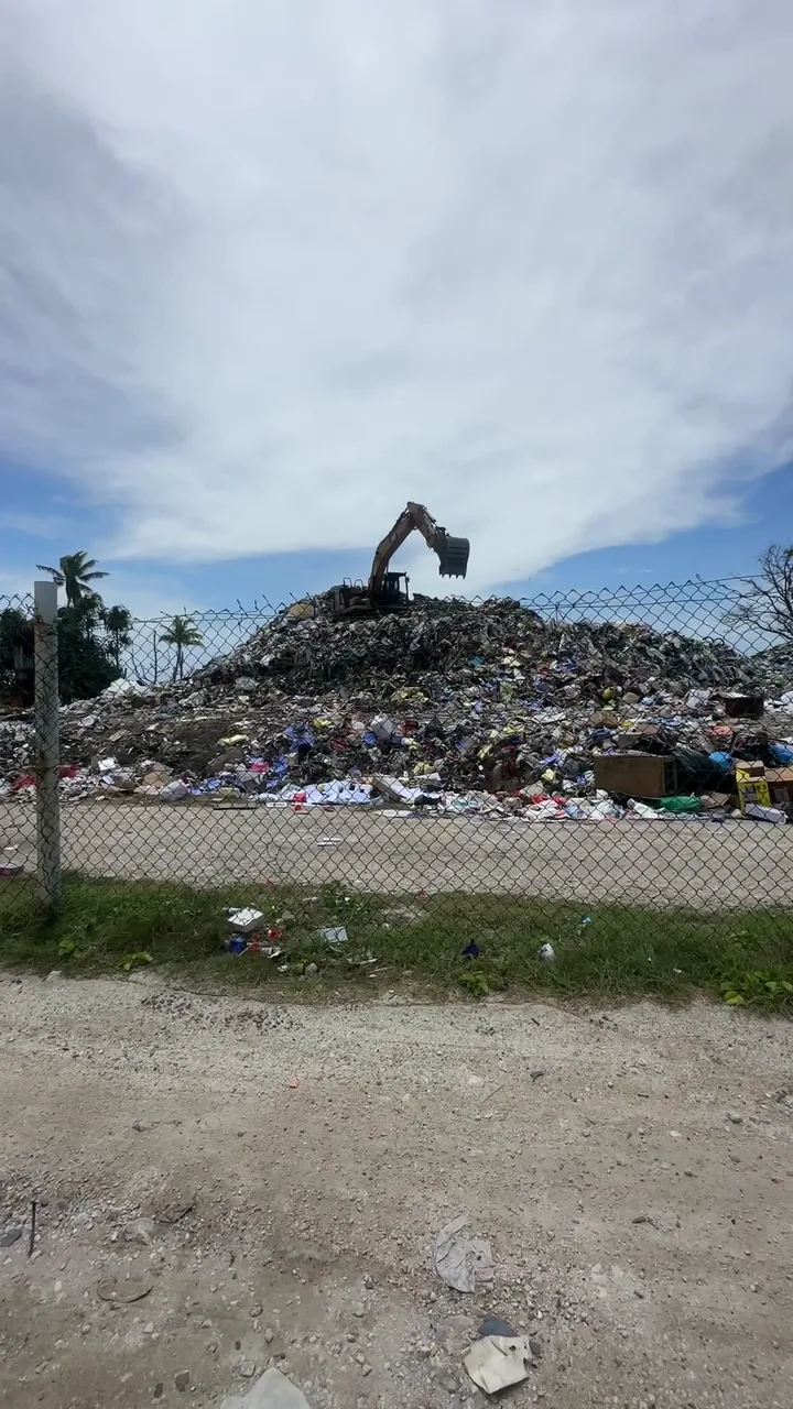 An excavator on a rubbish mound at the northern end of Fongafale. On site, the mound is higher than seven metres.